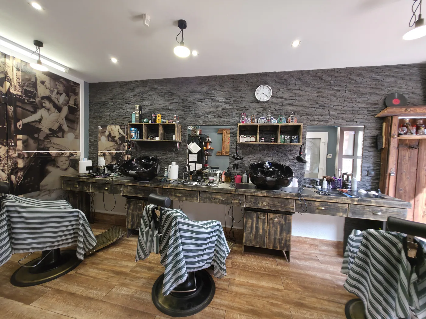 Interiér Barber Shop MF v Kežmarku — tri holičské kreslá, umývacie boxy a dlhý drevený pult