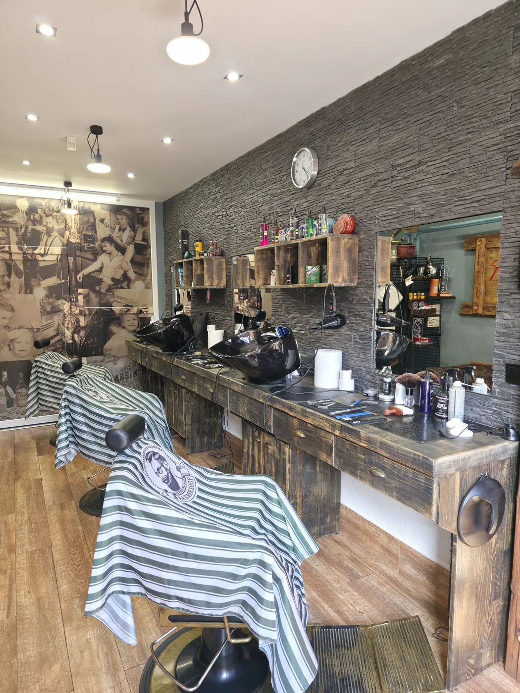 Interiér Barber Shop MF — kreslá, zrkadlá a kamenná stena v centre Kežmarku